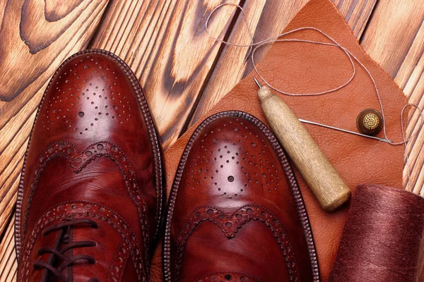 Fashion brogues shoes handmade and shoemaker tools hammer, awl, nails, skien of thread .Wooden background.Concept cobbler tools.copy space.top view — Stock Photo, Image