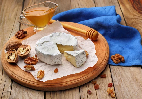 Camembert a brie sýr na dřevěné pozadí s ořechy koření a medu. Italské jídlo. — Stock fotografie
