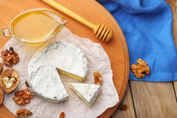 卡门培尔奶酪和干酪奶酪坚果香料与蜜的木制背景上。意大利食品。顶视图 — 图库照片