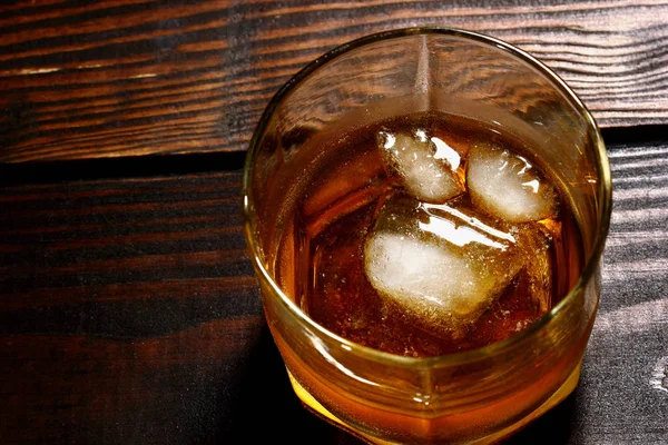 Overhead skott av glas whiskey med is på träbord — Stockfoto