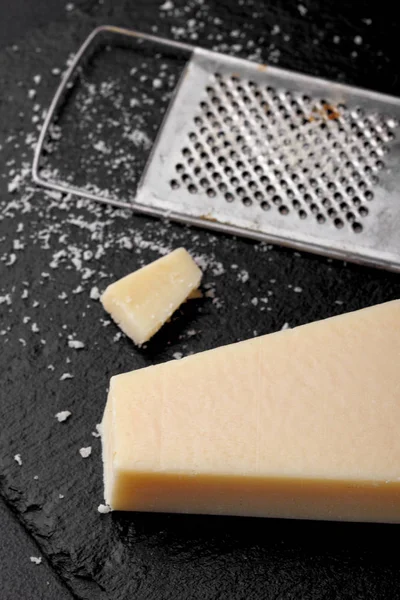 Formaggio di parmigiano con una grattugia.Cocnept proces con cibo. Grattugia — Foto Stock