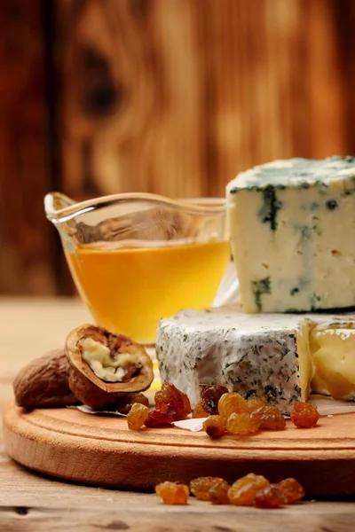 Olika typer av ost ädelost, parmesan, bree med honung, russin, valnöt. Selektiv fokus på bree — Stockfoto