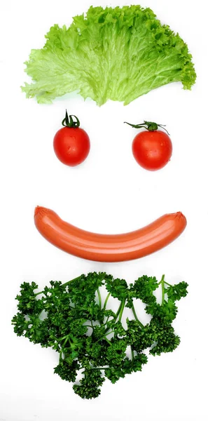 Joyeux souriantvisage de la nourriture- bouche de saucisse, cheveux - salade, yeux tomates, barbe persil Concept drôle food.Food art.Food émotion.white fond — Photo