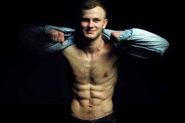 Yakışıklı genç adam mükemmel muscule beden ile kot gömlek ve poz kot pantolon giymiş. Poz