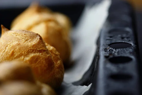 Французский десерт профитролей (эклер) на подносе choux pastry.Closeup.Selective фокус — стоковое фото