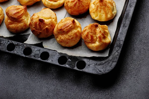 Profiteroles cozidos na bandeja pronta para croquembouche. Vista superior. Espaço de cópia. Foco seletivo — Fotografia de Stock