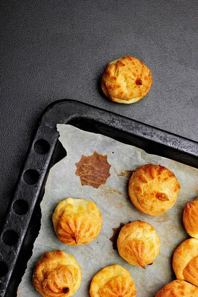 Profiteroles cozidos na bandeja pronta para croquembouche. Vista superior. Espaço de cópia. Foco seletivo — Fotografia de Stock