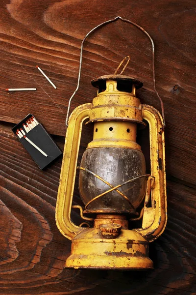 La vieille lanterne au kérosène posée avec des maatches éparses sur la table en bois — Photo