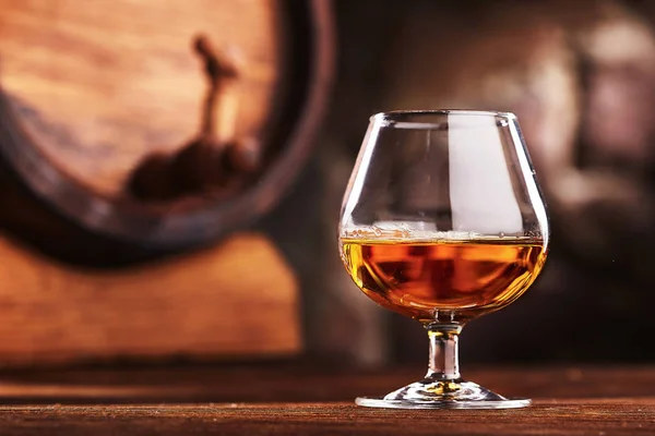 Verre de Cognac et vieux fût de chêne défocalisé — Photo