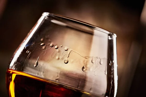 Vidrio con coñac closeup.taste de cognac.athmospheric foto — Foto de Stock