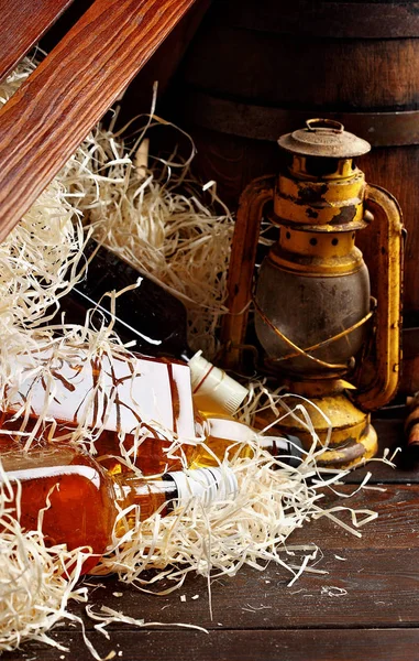 Whisky flessen. Posterous, omgekeerde vintage whiskey houten emballage box, kerosine lantaarn stijl olielampen, houten vat. Stilleven. Kopiëren van ruimte. — Stockfoto