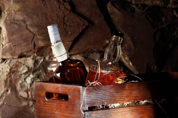 Una botella de whisky. En un conteainer de madera para transportar, caja con virutas de madera. Piedra background.copy espacio — Foto de Stock