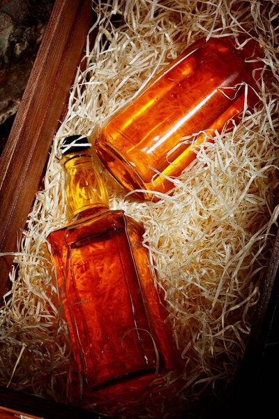 Bottle of whiskey. In a wooden conteainer for transporting, box with wooden chips. closeup.