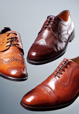 Moda klasik erkek kahverengi oxford brogues tonları kahverengi oxford brogues cilalı. Conept uçan ayakkabı. Gri arka planı
