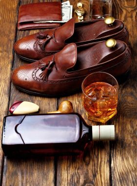 Kahverengi brogues ve erkekler accessroies kol düğmeleri, altın izle, tütününü boru, zencefil, şişe ve glas viski, deri potmone cüzdan para ile. Beyler kümesi.