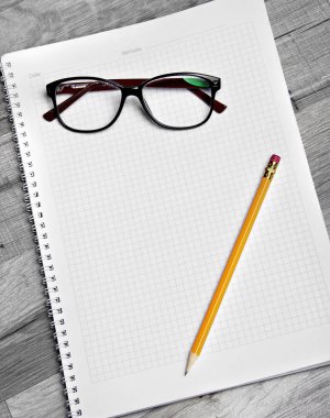 Defter bir kalem ve beyaz zemin üzerine gözlük ile boş, yazma ve düşünme kavramı için uygun.