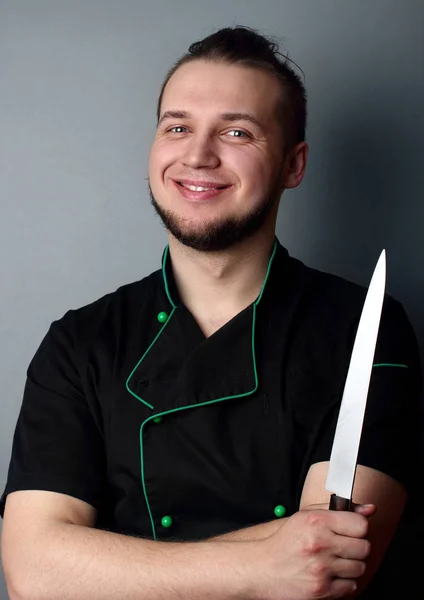 Chef sorrindo com faca em bakcground.Chef.Portrait cinza — Fotografia de Stock