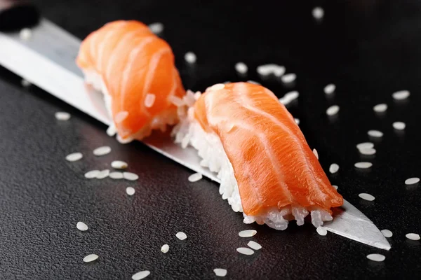 Nigiri sushi z łososiem na nóż na czarnym tle — Zdjęcie stockowe