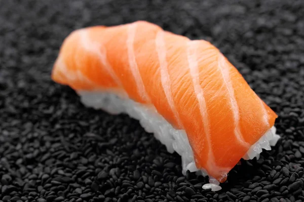 Salmone sushi nigiri su sfondo nero sesam — Foto Stock