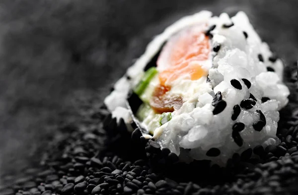 Japanese sushi roll philadelphia on black sesame. Selective focus. Blurred foreground and background. Macro view — Stock Photo, Image