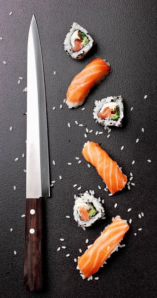 Суши нигири сушими с лососем и ролл суши филадельфия с ножом для суши. Над каменной подложкой. Копируйте пространство. Японская еда. . — стоковое фото