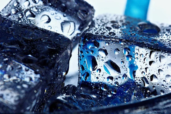 Duidelijke smeltende ijsblokjes in een glas water met druppels. Closeup — Stockfoto