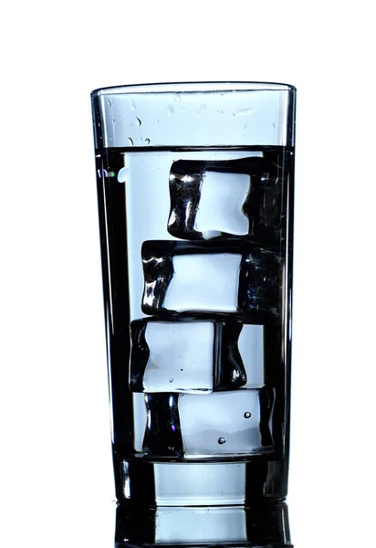 Ett glas rent vatten med isbitar. Isolerad på vit bakgrund — Stockfoto