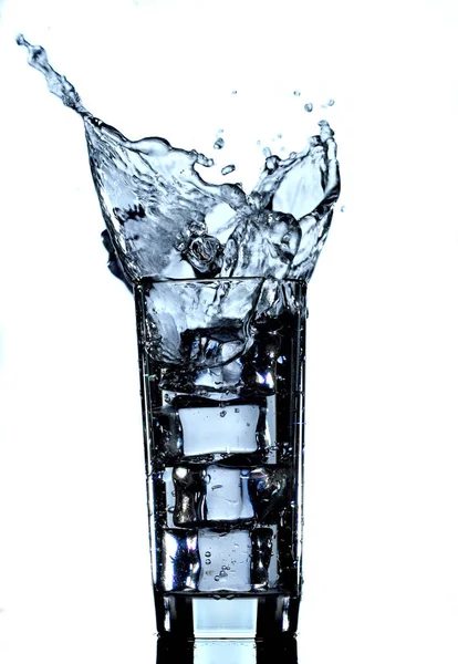 Agua en vidrio salpicando aislada sobre fondo blanco — Foto de Stock