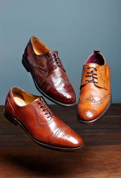 Mode klassische polierte Männer braun Oxford Brogues Schattierungen von braunen Oxford brogues.conept fliegende Schuhe.grauer Hintergrund — Stockfoto