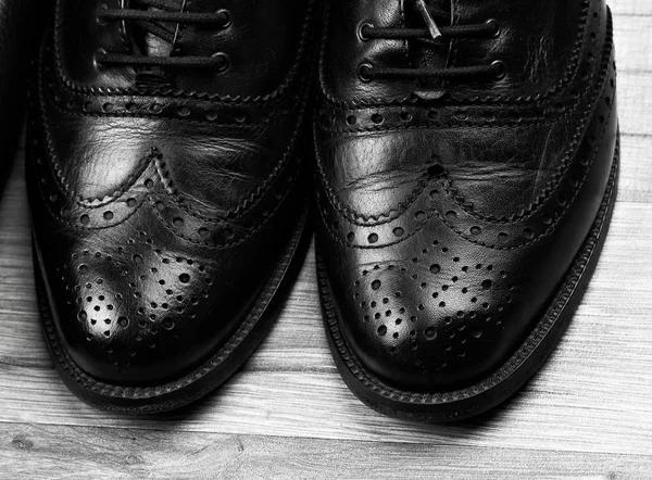 Black oxford shoes with shoelace on black background closeup, top view — Stock Photo, Image
