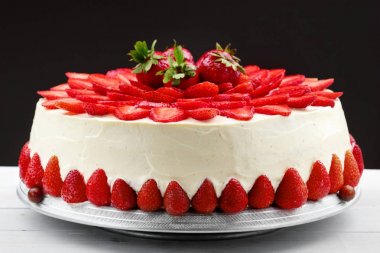 Vanilyalı krema ile Çilekli pasta. Siyah arka plan.