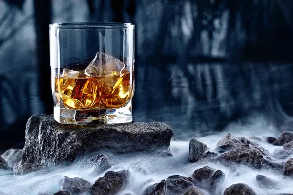 Glas whiskey och is. Kreativa foto glas whiskey på sten med dimma och kyla bakgrund. Kopiera utrymme. Reklam skott — Stockfoto