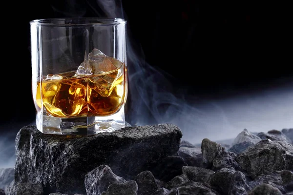 Glas whiskey en ijs. Creatieve foto glas whisky op steen met mist. Kopieer ruimte. Schot reclame — Stockfoto