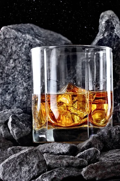 Glas whiskey och is. Kreativa foto glas whiskey i stone mountain. Kopiera utrymme. Reklam skott — Stockfoto