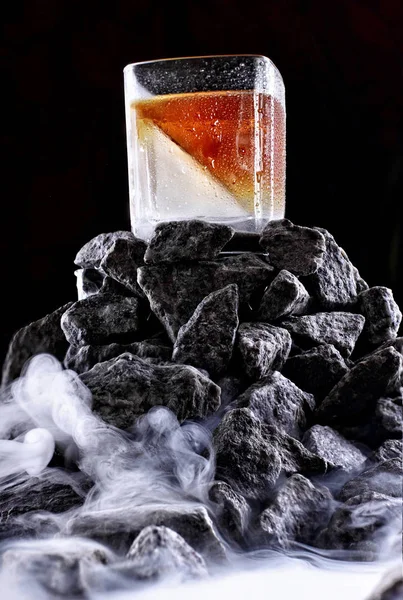 Cam yarım bardak buzlu viski. Sis ile taş dağda. Yaratıcı fotoğraf. Reklam atış — Stok fotoğraf