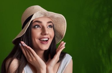 Portre yaz yeşil tropic arka plan üzerinde izole şapka poz içinde güzel bir gülümseyen kız şaşırttı. Cocnept yaz discout. Şok