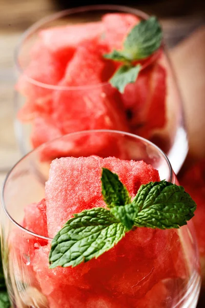Karpuz. Glasess içinde küpler halinde kesilmiş Closeup karpuz nane ile dekore edilmiştir. Seçici odak.