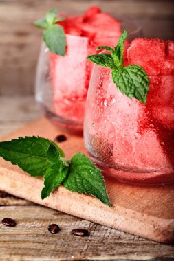 Karpuz. Glasess su damlaları ile küpler halinde kesilmiş karpuz rustik ahşap masa nane ile dekore edilmiştir. Karpuz seds. Uzay kopyalayın. Seçici odak