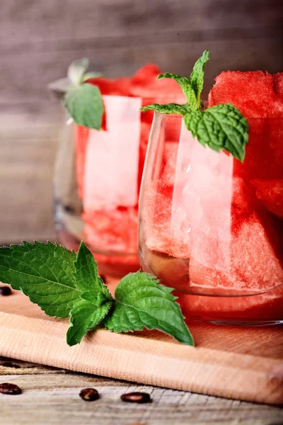 Karpuz. Karpuz rustik ahşap masa nane ile dekore edilmiş glasess içinde küpler halinde kesilmiş. Karpuz seds. Uzay kopyalayın. Seçici odak