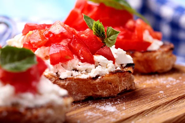 Domates, beyaz peynir, fesleğen, dereotu ve baharat ve olivia ile lezzetli bruschetta ahşap tahta üzerinde petrol. Clsoeup.Selective odak