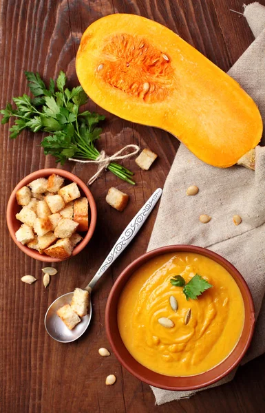 Sopa de crema de calabaza en mesa de madera.Sopa casera de calabaza de mantequilla de otoño con croutons.Otoño.Vista superior —  Fotos de Stock