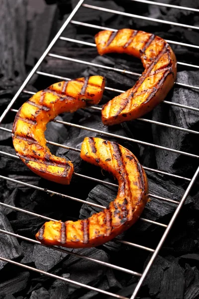 Calabaza asada en una rejilla sobre fondo de carboncio.Calabaza barbacoa . —  Fotos de Stock