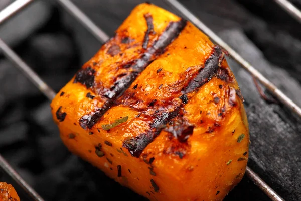 Calabaza asada en una rejilla sobre fondo de carboncio.Calabaza de barbacoa.Primer plano, macro shot —  Fotos de Stock