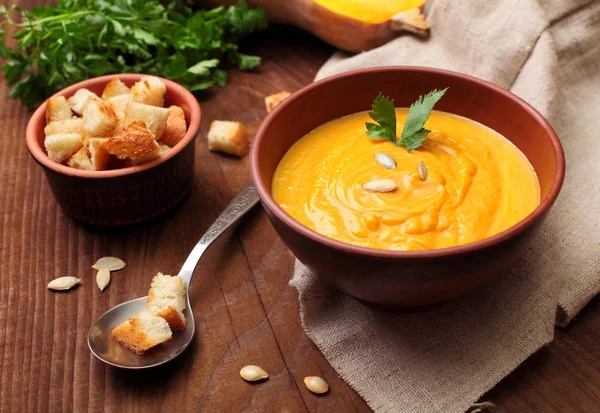Pompoen crème soep op houten tafel. Zelfgemaakte herfst pompoen soep met croutons. Herfst schotel — Stockfoto
