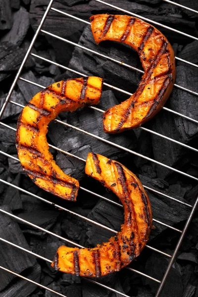 Calabaza asada en una rejilla sobre fondo de carboncio.Calabaza barbacoa . —  Fotos de Stock