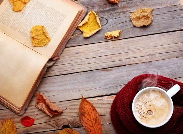 Fincan sıcak cappuccino kahve ahşap tablo sonbahar yaprakları, kitap. Sonbahar ruh kavramı. Sıcak Sonbahar resim. Seçici odak. Space.top görünüm Kopyala