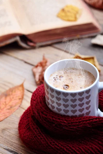 Fincan sıcak cappuccino kahve ahşap tablo sonbahar yaprakları, kitap. Sonbahar ruh kavramı. Sıcak Sonbahar resim. Seçici odak.
