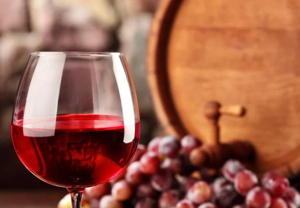 Czerwone wino. Zbliżenie kieliszek czerwonego wina, winogrona i beczki. Selektywny fokus. Winiarnia atmosferę. Miejsce. — Zdjęcie stockowe