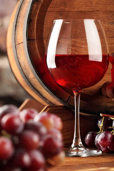 Vino tinto. Copa de primer plano de vino tinto, uvas y barrica. Enfoques selectivos. Ambiente de bodega. Espacio para copiar . — Foto de Stock