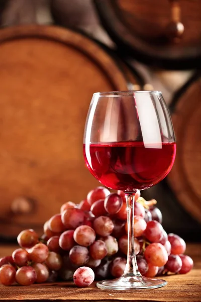 Vino tinto. Copa de primer plano de vino tinto, uvas y barrica. Enfoques selectivos. Ambiente de bodega. Espacio para copiar . — Foto de Stock